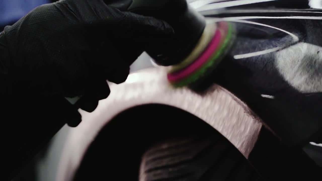 Real workshop footage of a technician polishing black paint