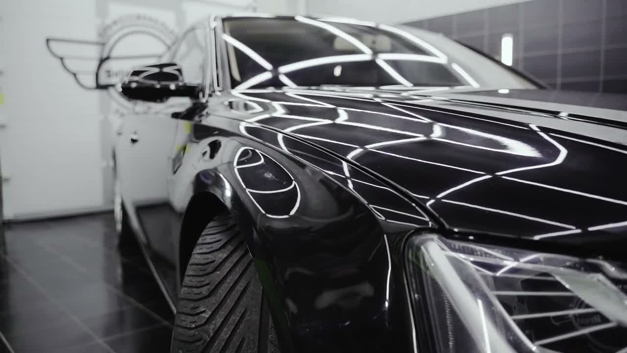 Finished black car in a detailing workshop